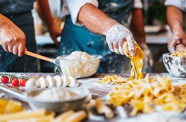 A group of individuals making pasta from scratch