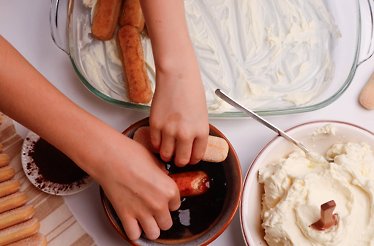 Someone making tiramisu from scratch