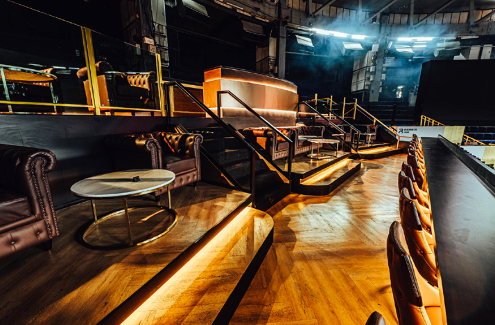The interior of the VIP lounge on the Rajadamnern Stadium with armchairs and a bar.