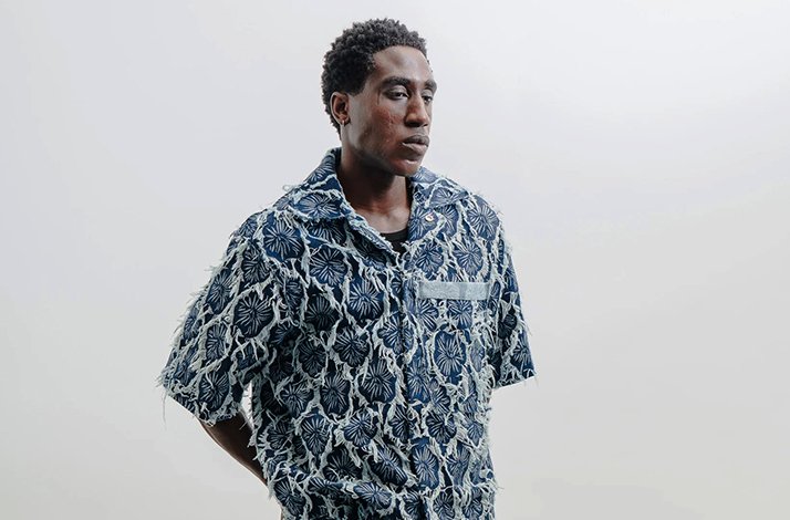 A model wearing the Nowrubi Raffia Denim Shirt in Indigo Blue.