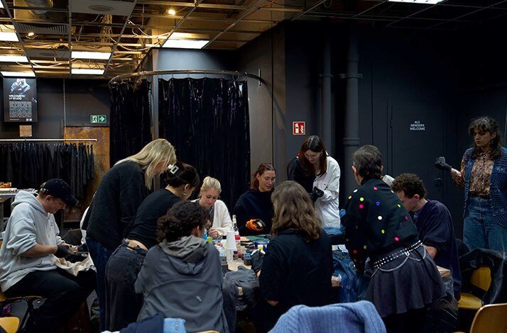 Participants gathered around a worktable crafting latex accessories during HADERLUMP  event.