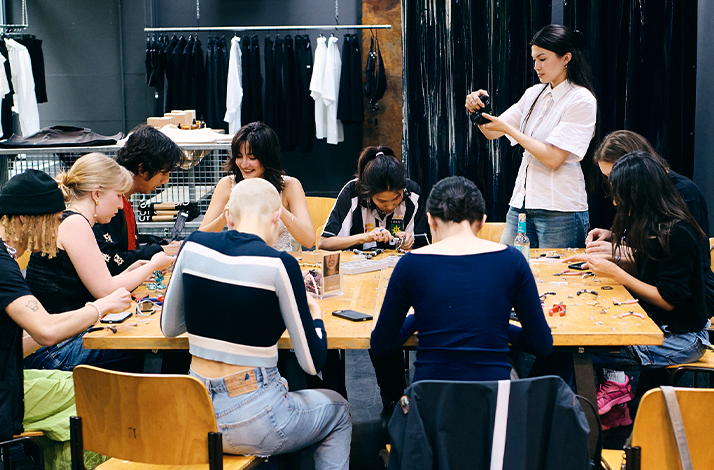 A group of people on a table during a hands-on upcycled beading workshopat Amike Studio