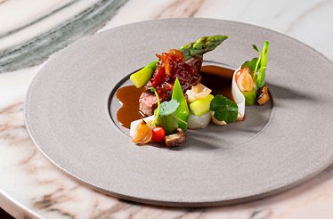 A dish is being laid out on the plate to be served at NOVO New Dining.