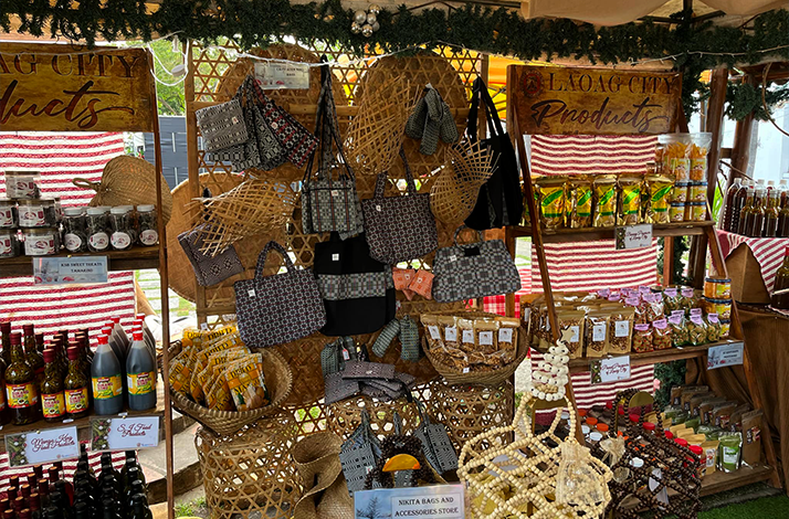 Local market stall in Laoag City displaying woven bags, baskets, bottled sauces, and traditional snacks.