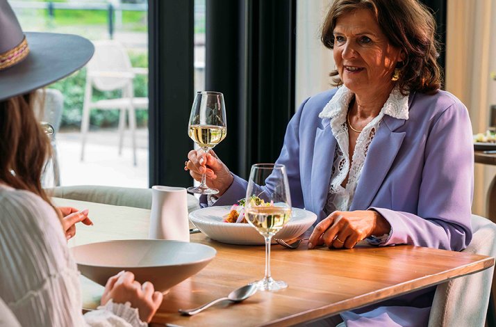 Two ladies sitting at the table and enjoying their time.