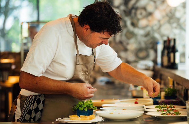 A chef carefully plating dishes at Kasteel Steenenburg.
