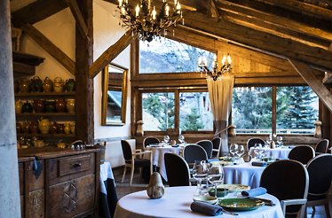 Interior of Michelin-starred La Bouitte in Saint-Martin-de-Belleville restaurant with tables served for guests.