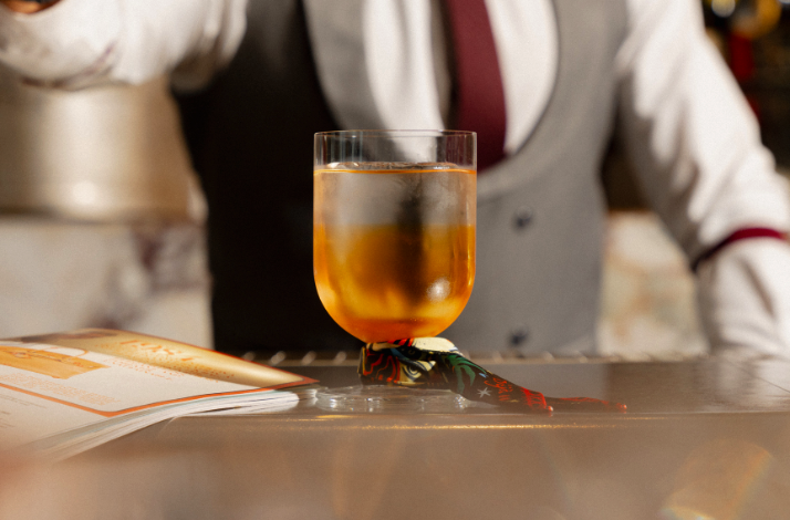 A bartender preparing a drink with ice cubes.