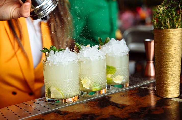 Fresh cocktails being prepared with crushed ice and mint.