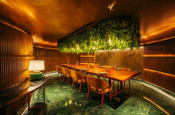 Elegant private dining room with lush greenery and warm lighting.