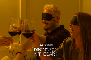 Two blindfolded people cheering with wine glasses. Text at the bottom: 'fever Original. Dining in the Dark'.