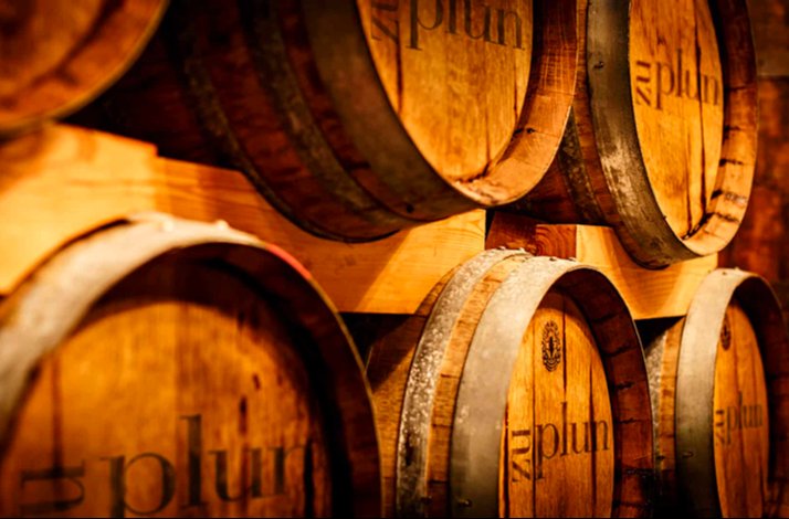 Stacked wooden barrels with metal rims, marked Zu Plun.