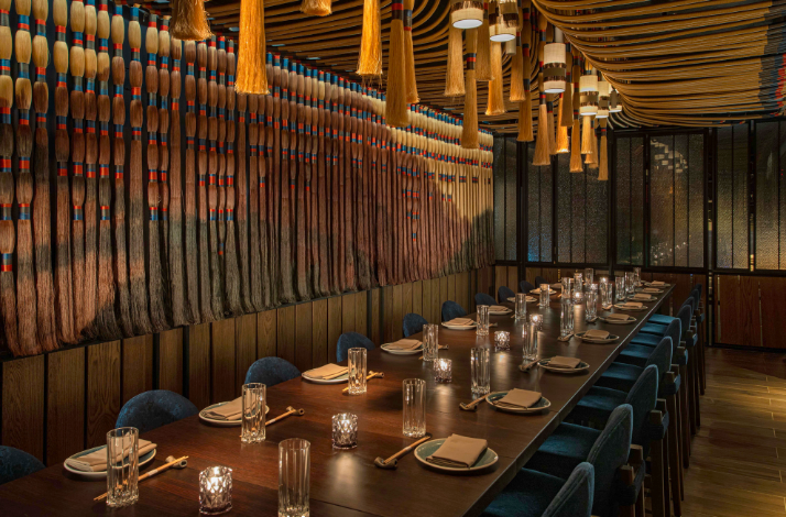 A large dining table set for guests in a warm, cozy atmosphere at Sake No Hana restaurant in NYC