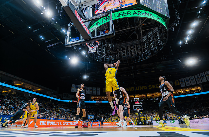 Basketball players in action during a game, showcasing dynamic movement on the court.