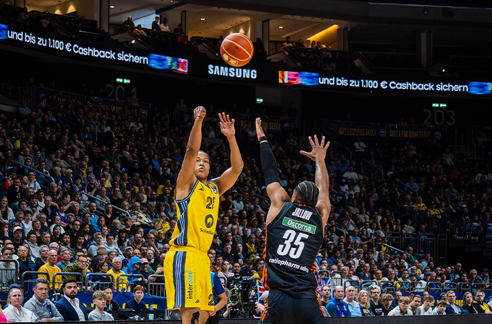 Basketball players in action during a game, showcasing dynamic movement on the court.