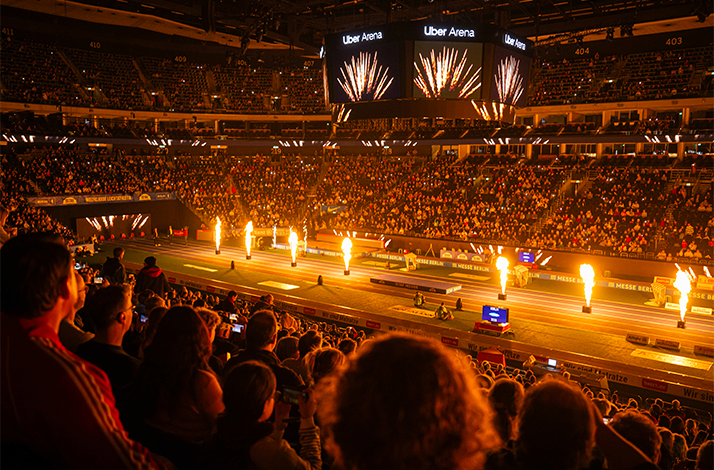 Crowd watching fiery track‑and‑field show inside Uber Arena during ISTAF Indoor