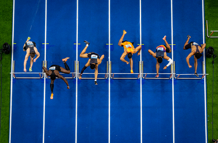 Runners approaching the finish line on a blue track at ISTAF Indoor