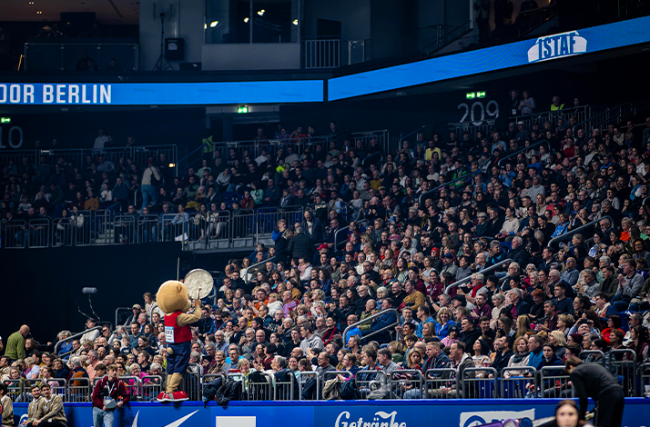 Packed audience at ISTAF Indoor with event mascot engaging the crowd
