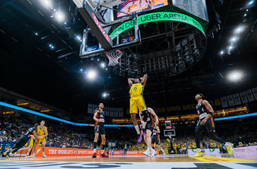 Basketball players in action during a game, showcasing dynamic movement on the court.