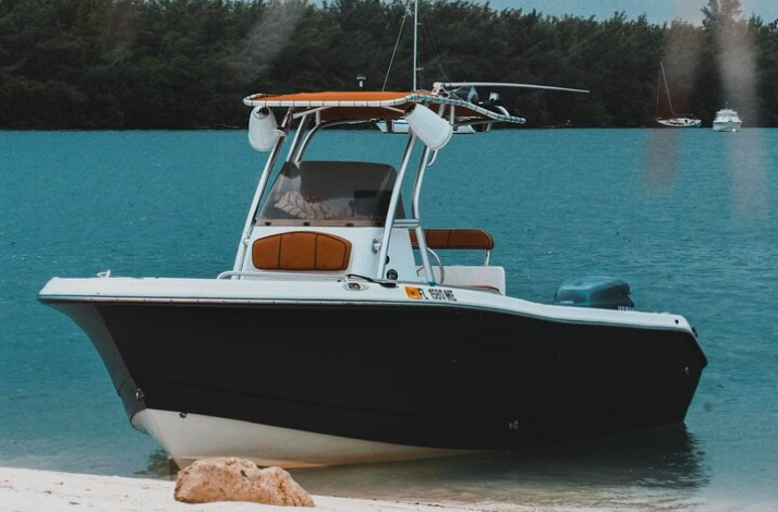  Small motorboat anchored by a sandy shore.