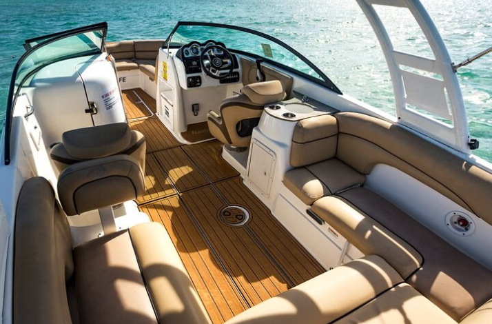 Interior of a luxury motorboat with tan seating on the water.