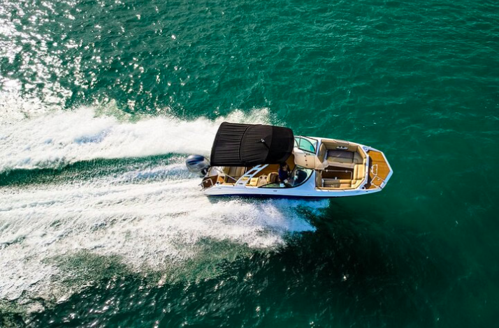 Overhead view of a motorboat speeding across turquoise water.