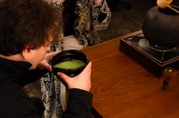 A person holding a large matcha cup served at THE GALLERY by odo.