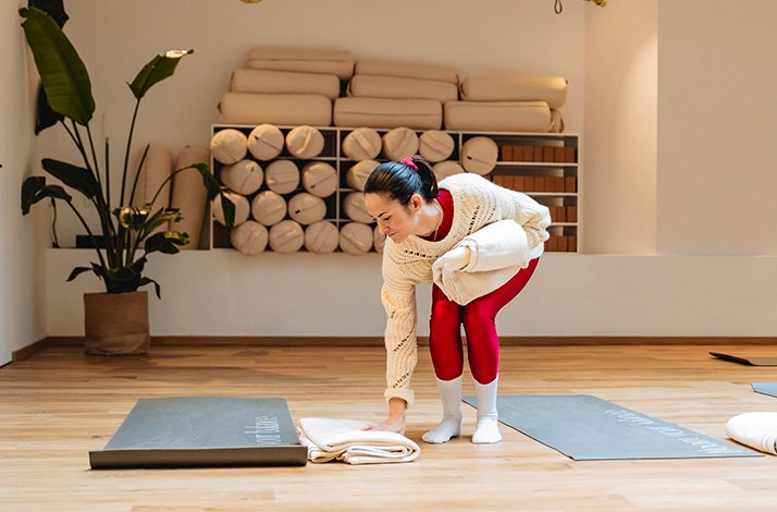 A woman practicing yoga on a mat, demonstrating a focused pose in a serene indoor environment.