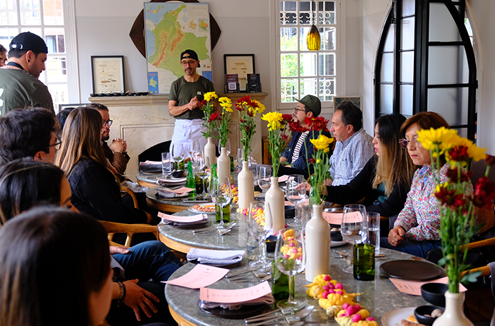 Interior of the restaurant showcasing modern design elements and artisan details, including a colorful wall tapestry that adds warmth to the space