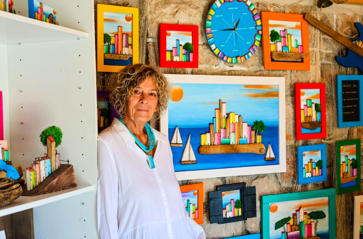 Display of driftwood cityscape art and clocks inside the shop, with bright, playful colors.