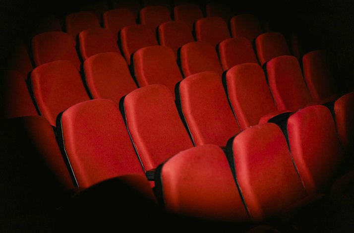Seats at the Athens Conservatoire highlighted by a spotlight.
