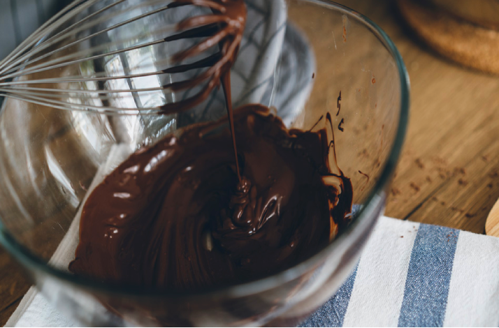 Chocolate being whisked in a glass bowl, ready for baking.