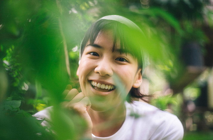 A person surrounded by lush green plants during a Thai herbal exploration.