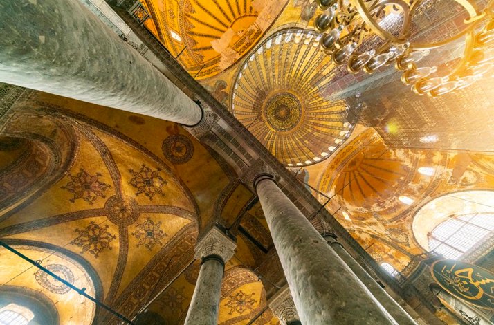 An interior view of the dome showing the columns, carvings, and decorations of Hagia Sophia.