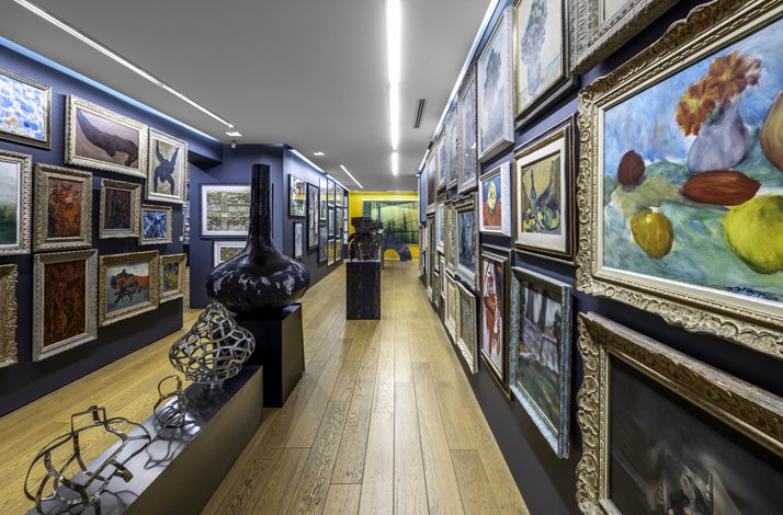 A photograph of the paintings on the wall in a long corridor and the decorative artworks in the central area.