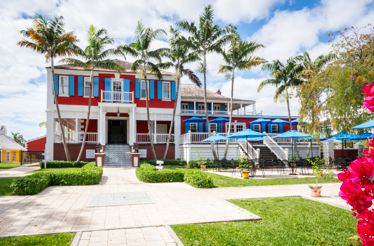 Exterior of John Watling’s Distillery surrounded by palm trees.