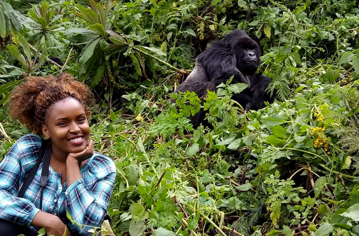 A tourist posing for the photo near a gorilla