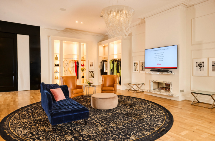 Luxurious styling studio with designer clothing displays and elegant seating.