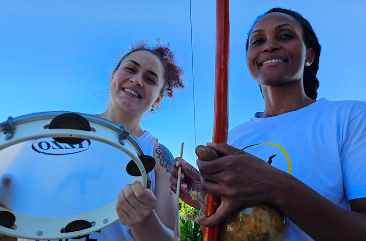 Traditional capoeira instruments being played during a private seaside session in Rio de Janeiro, setting the rhythm for an immersive cultural experience