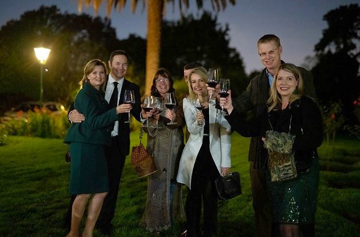 Visitors cheering with wine glasses in the garden of A Symphony of Soil & Soul by SecretEATS in South Africa's Highveld.