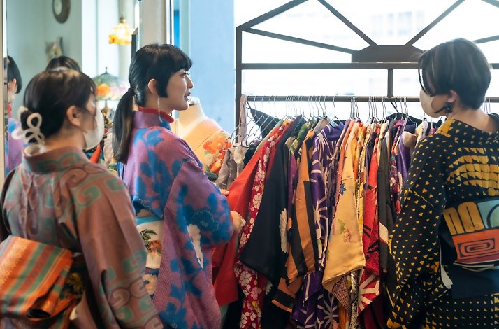Sankak helping visitors select vintage kimonos for a retro photoshoot.