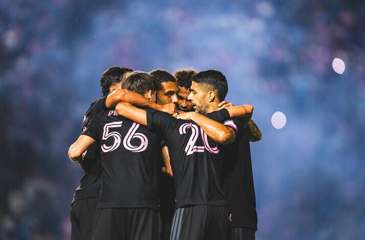 Inter Miami CF players huddling on the pitch during a match.