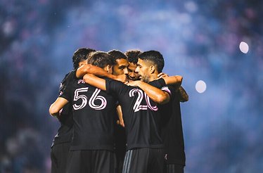 Inter Miami CF players huddling on the pitch during a match.