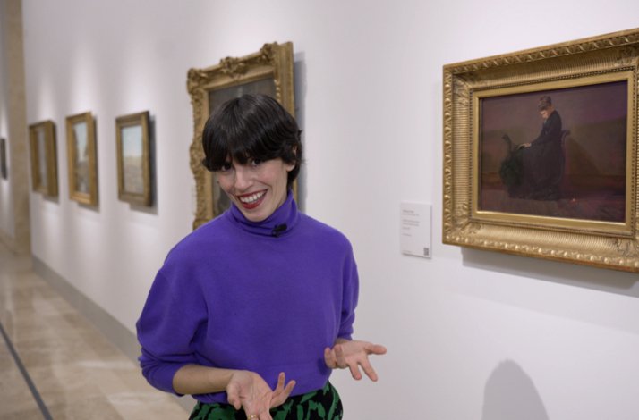 Coco Dávez standing in front of a painting giving a tour of the Thyssen-Bornemisza National Museum