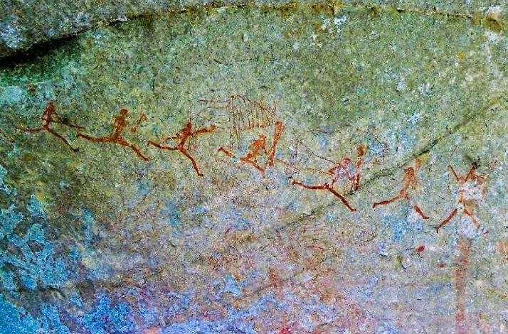 A rock featuring a painted depiction of people, showcasing artistic expression in a natural setting.