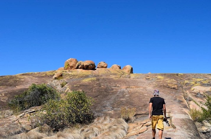 A rock featuring a painted depiction of people, showcasing artistic expression in a natural setting.
