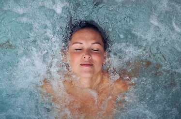 Person relaxing with their eyes closed in jacuzzi at Fort Resort Beemster.