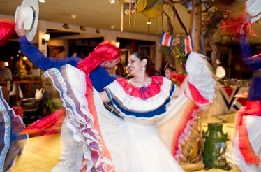 Man and woman dance in traditional Costa Rican costumes.