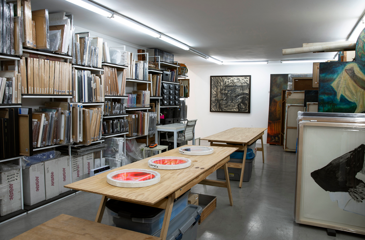 Interior workspace at Hache Galería with shelves and worktables