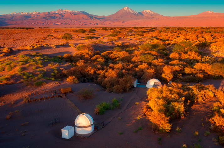 Observatory and Andean landscape at sunset with mountains illuminated by golden light